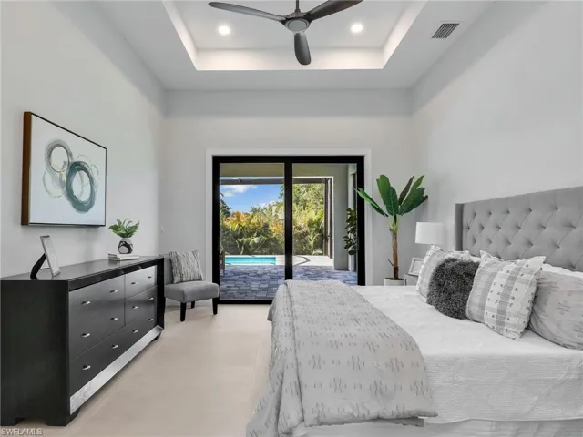 Bedroom with recessed lighting, a raised ceiling, visible vents, and access to exterior