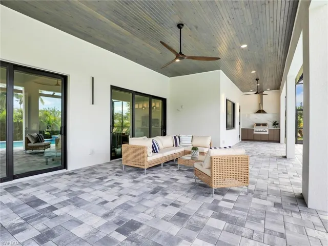 View of patio with ceiling fan, outdoor lounge area, and an outdoor kitchen