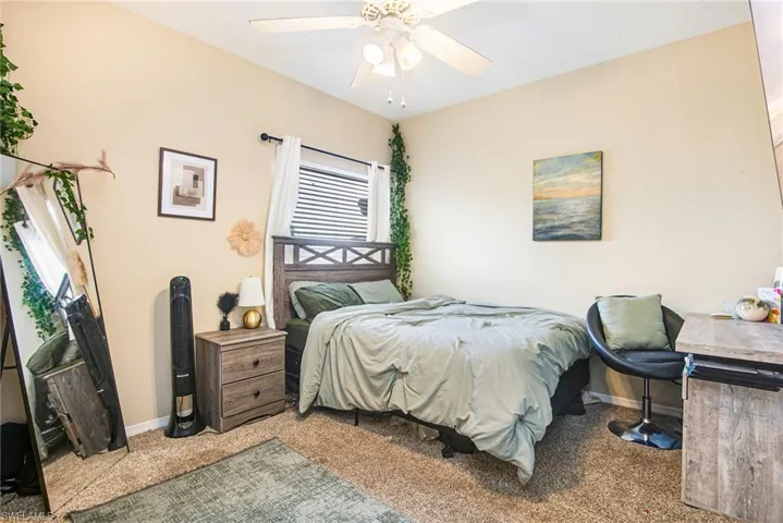 Carpeted bedroom featuring baseboards and a ceiling fan