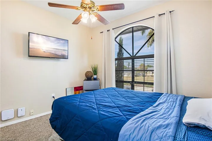 Carpeted bedroom featuring baseboards and a ceiling fan