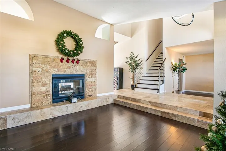 Unfurnished living room with stairway, hardwood / wood-style floors, and a fireplace