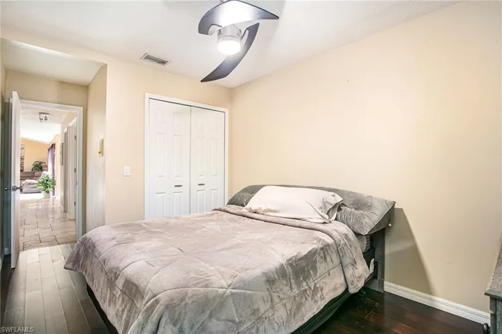 Bedroom with wood-type flooring, a closet, and a ceiling fan