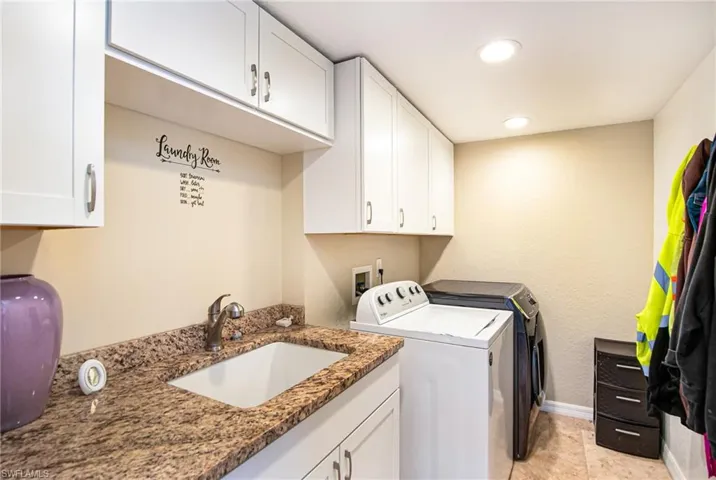Laundry area featuring washing machine and dryer, cabinet space, recessed lighting, and light tile patterned floors