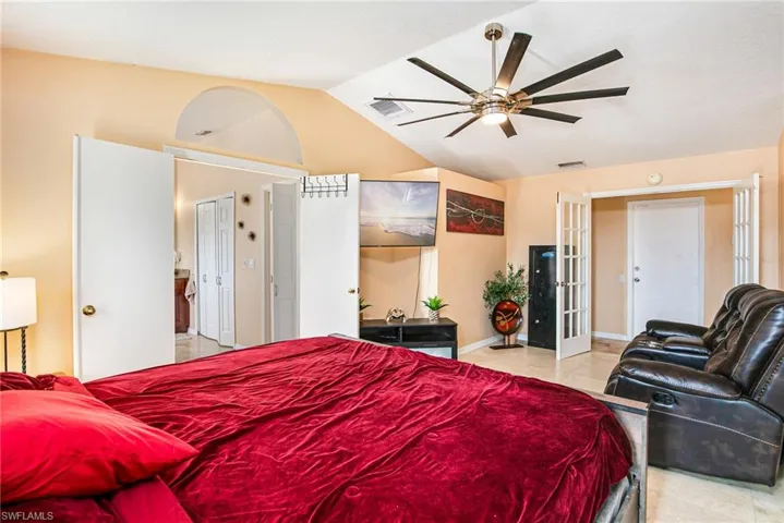 Bedroom featuring french doors, ceiling fan, vaulted ceiling, and light tile patterned floors