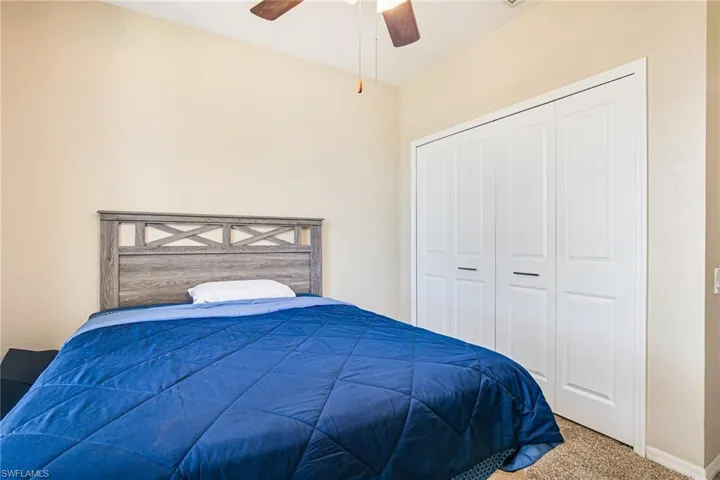Bedroom featuring carpet flooring, a ceiling fan, and a closet