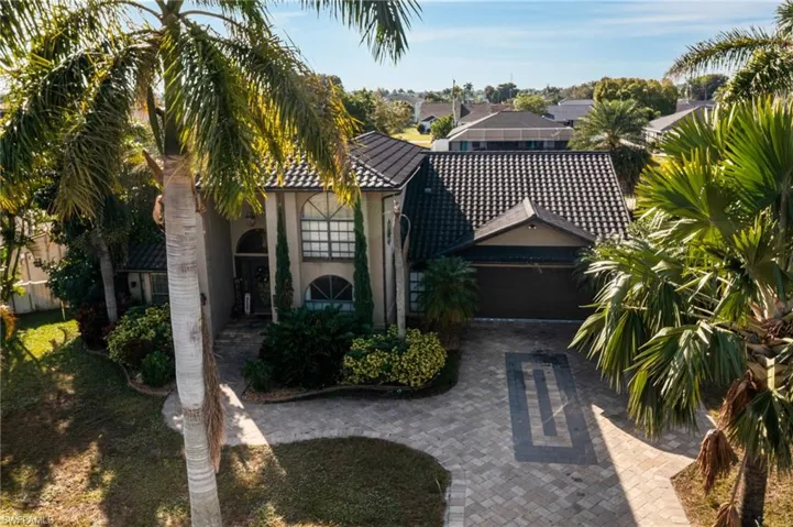 View of front of property with decorative driveway, stucco siding, and a garage