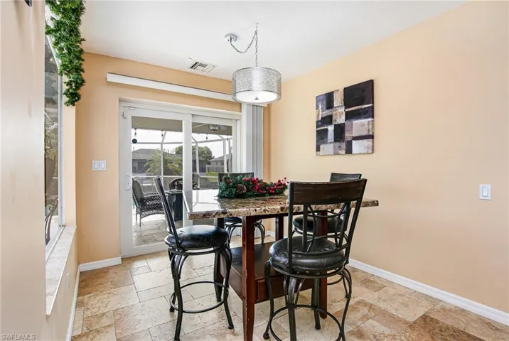Dining room featuring stone tile floors and baseboards