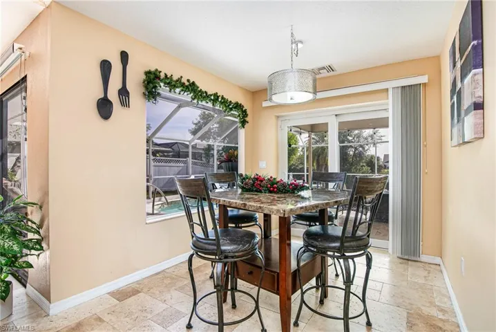 Dining room with stone tile floors and a sunroom