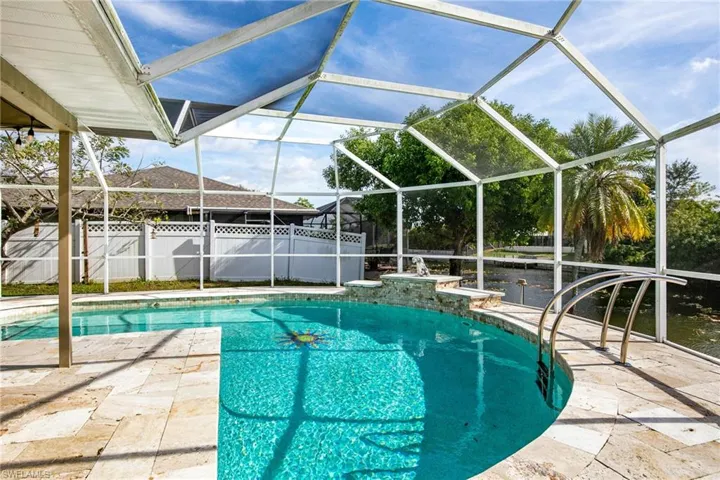 View of pool featuring glass enclosure, a sunroom, and a patio