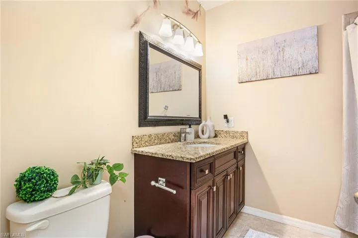 Bathroom with vanity, a shower with curtain, and light tile patterned floors