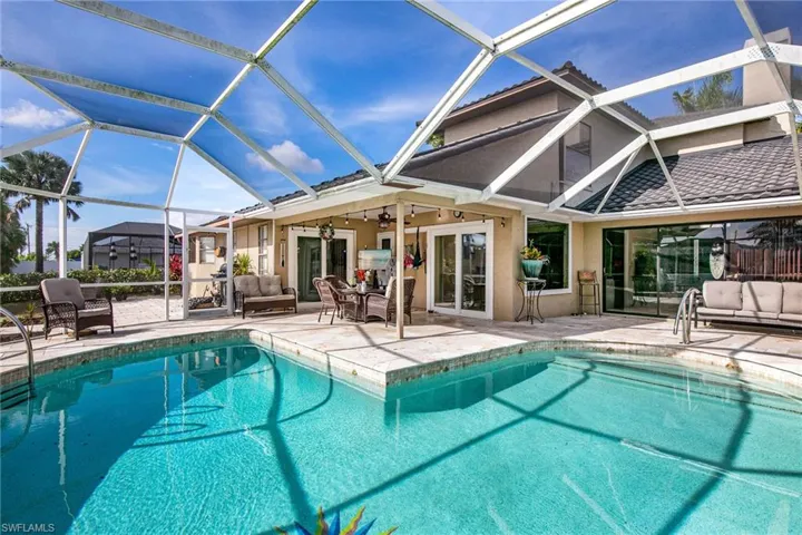 Outdoor pool with outdoor lounge area, a sunroom, a lanai, and a patio