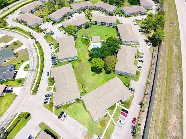 Aerial perspective of a multi-building residential complex featuring a central courtyard with a swimming pool