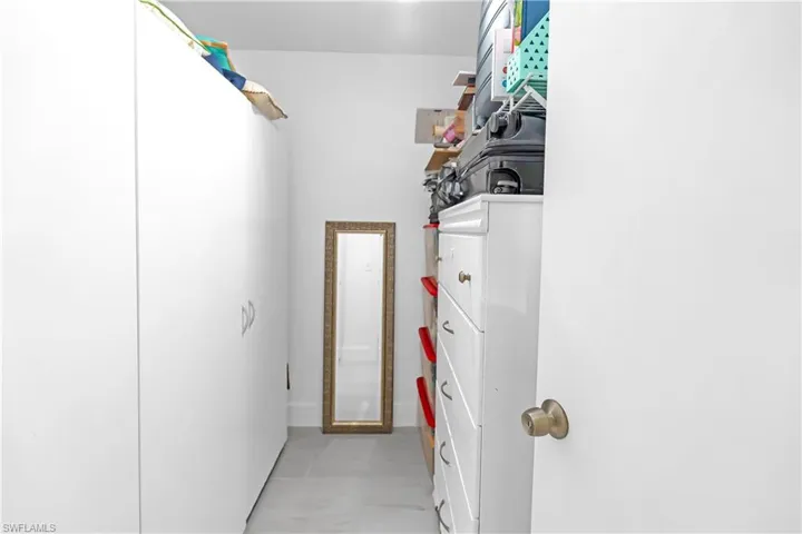 White built-in cabinetry with silver hardware provides ample storage