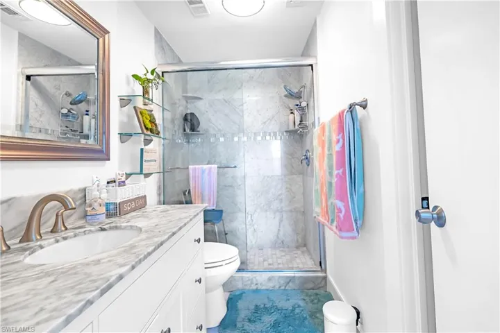 Integrated vanity with an undermount sink, a marble-patterned countertop, and brushed nickel fixtures