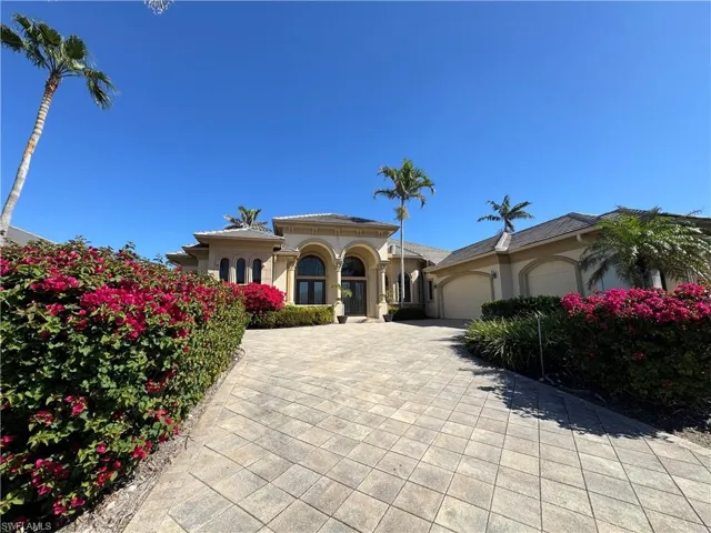 Mediterranean / spanish-style home with an attached garage, decorative driveway, and stucco siding