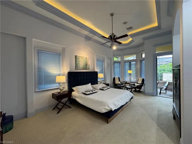 Bedroom with visible vents, baseboards, ornamental molding, carpet, and a raised ceiling