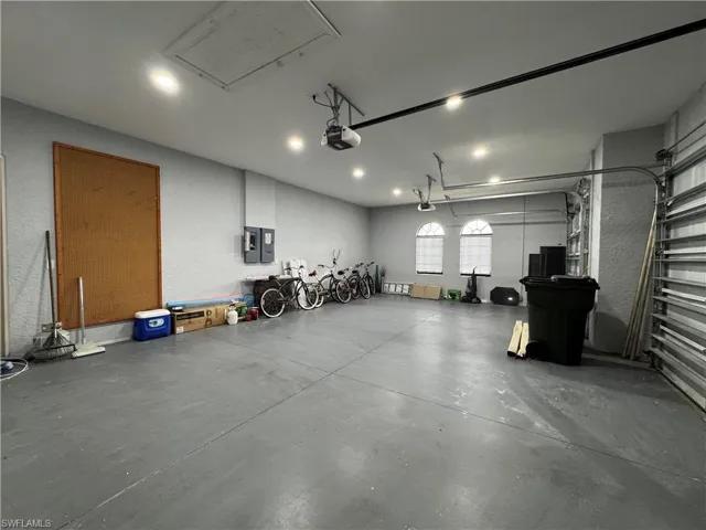 Garage featuring electric panel and a garage door opener