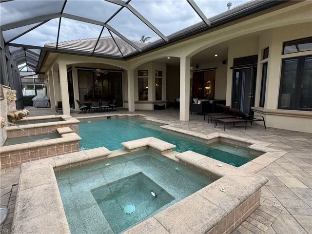 View of swimming pool featuring a patio area, ceiling fan, and a pool with connected hot tub