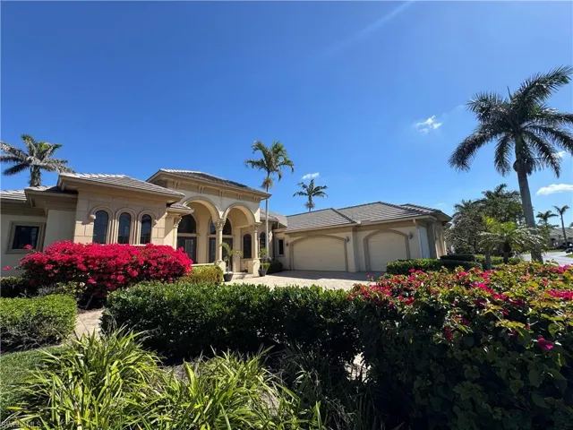 Mediterranean / spanish home with a tiled roof, an attached garage, and stucco siding
