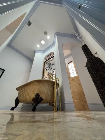 Room details featuring arched walkways, ornamental molding, and visible vents