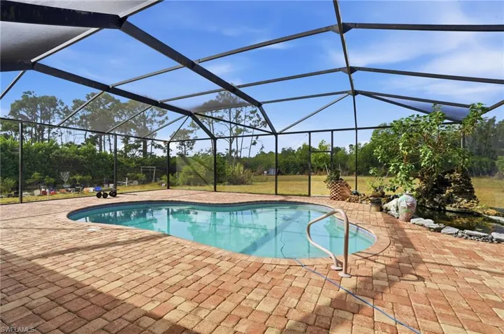 Swimming pool featuring glass enclosure, a sunroom, and a patio area