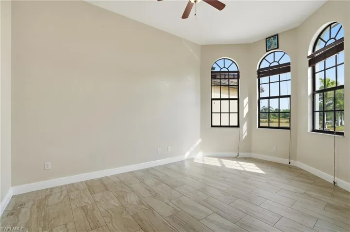Den with baseboards and ceiling fan