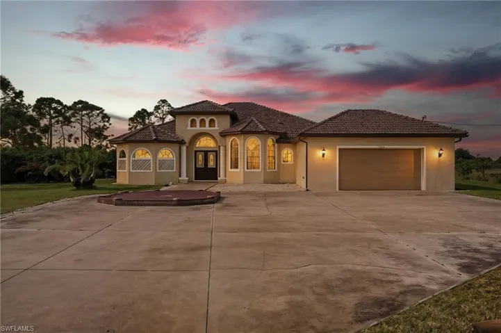 Mediterranean / spanish home with stucco siding, concrete driveway, a garage, and a tile roof