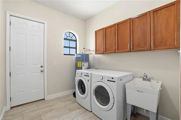 Laundry room featuring independent washer and dryer and cabinet space