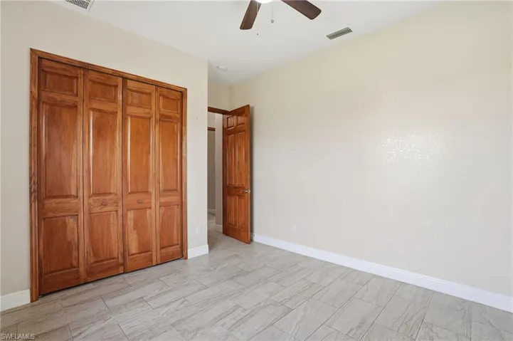 Bedroom with ceiling fan and a closet