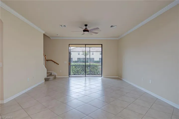 Unfurnished room featuring a ceiling fan, crown molding, and light tile patterned flooring