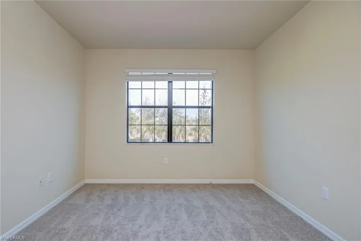 Spare room with light colored carpet and baseboards
