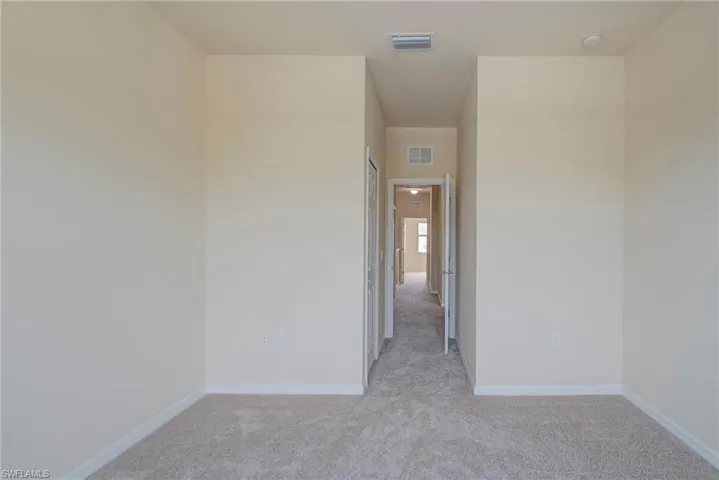Unfurnished room with light carpet and baseboards