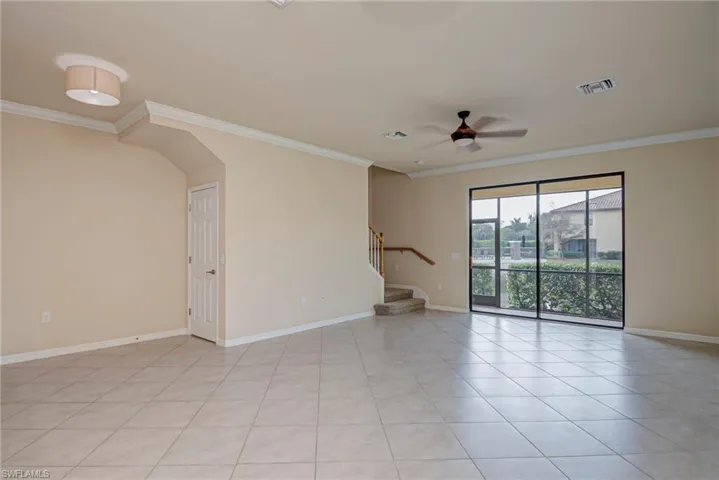Unfurnished room featuring ornamental molding, ceiling fan, and light tile patterned flooring