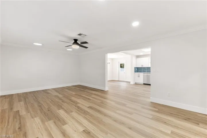 Unfurnished living room featuring light wood-type flooring, ornamental molding, recessed lighting, and a ceiling fan