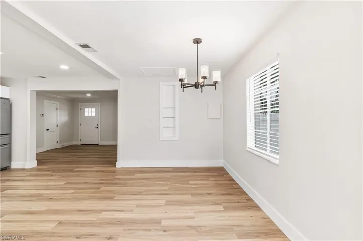 Unfurnished dining area featuring light wood-type flooring, recessed lighting, and a chandelier