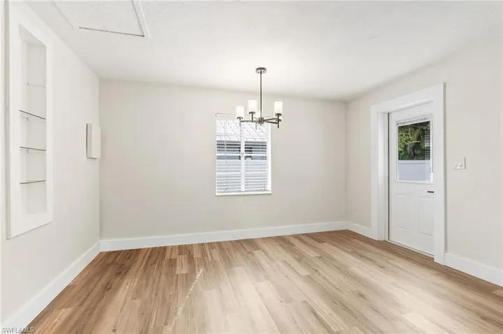 Unfurnished dining area with light wood-type flooring and a chandelier