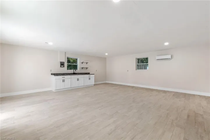 Unfurnished living room featuring recessed lighting, light wood finished floors, and a wall mounted air conditioner
