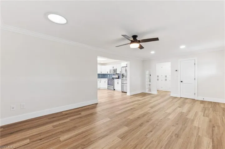 Unfurnished living room with ornamental molding, light wood-type flooring, recessed lighting, and ceiling fan