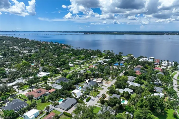 Aerial perspective of suburban area featuring a notable bridge and a nearby body of water