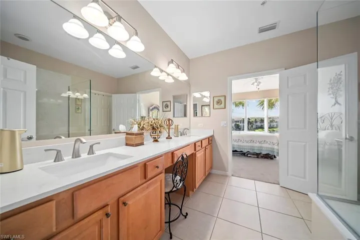 Bathroom with tile patterned flooring, vanity, and a shower with door