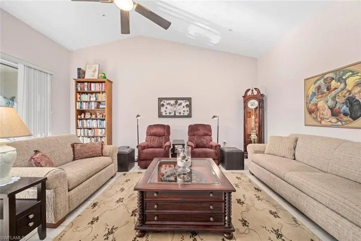 Living room with ceiling fan and lofted ceiling