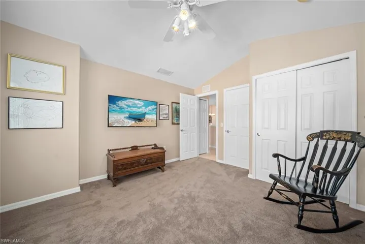 Sitting room featuring ceiling fan, carpet, and vaulted ceiling