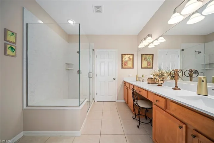 Bathroom with tile patterned floors, vanity, and a shower with shower door