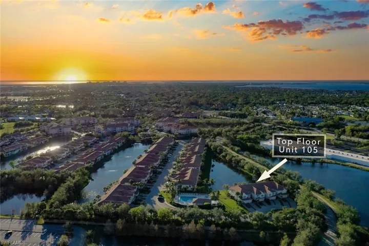 Aerial view at dusk featuring a water view