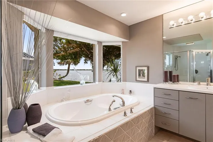 Bathroom featuring vanity, a shower stall, healthy amount of natural light, and a bath