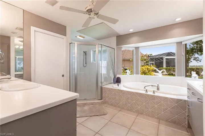 Full bathroom featuring tile patterned flooring, healthy amount of natural light, vanity, a shower stall, and recessed lighting