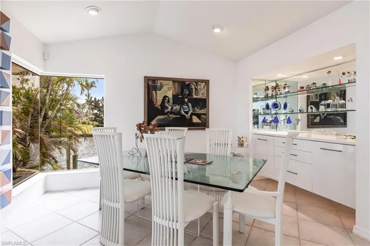 Dining room featuring lofted ceiling, light tile patterned floors, and recessed lighting