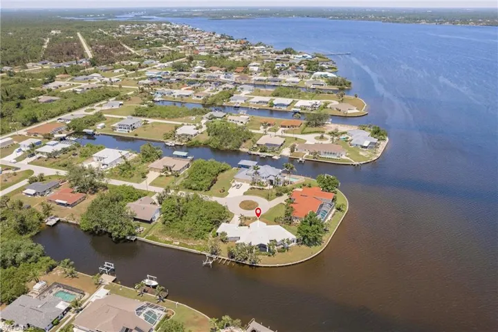 Aerial view of property and surrounding area with a large body of water and nearby suburban area