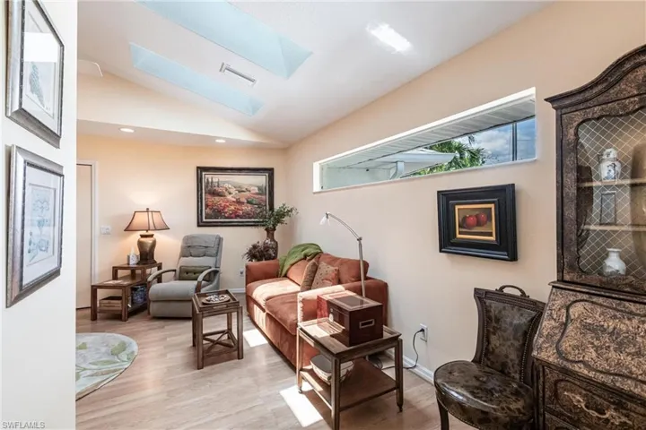 Living area featuring a skylight, light wood-style floors, lofted ceiling, and recessed lighting