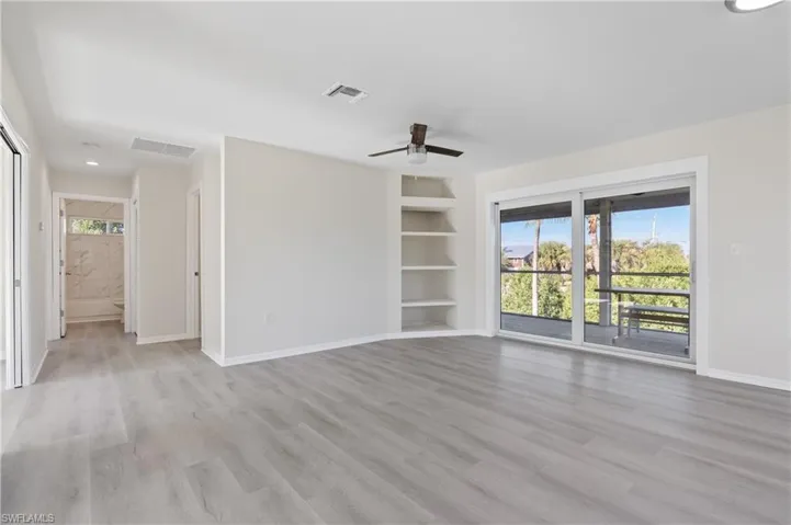 Livingroom with healthy amount of natural light, light wood-style LVP flooring, a ceiling fan, built in shelves, and recessed lighting